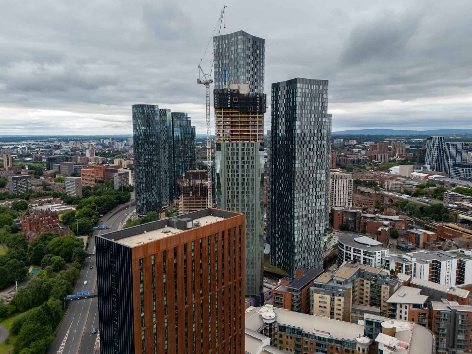 City skyline featuring tall glass skyscrapers under cloudy sky.