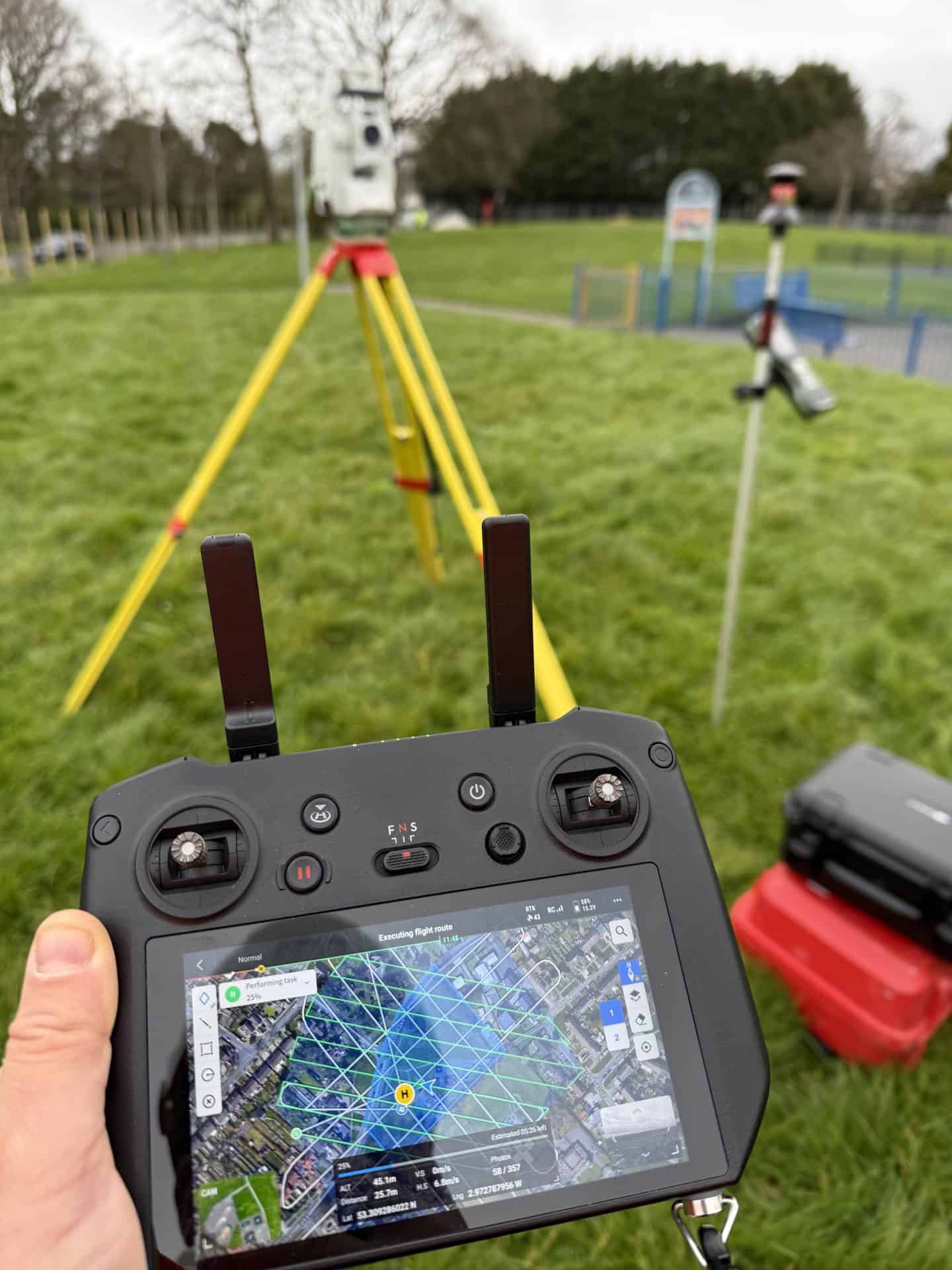 Drone surveying equipment with GPS and mapping tools in a park setting.