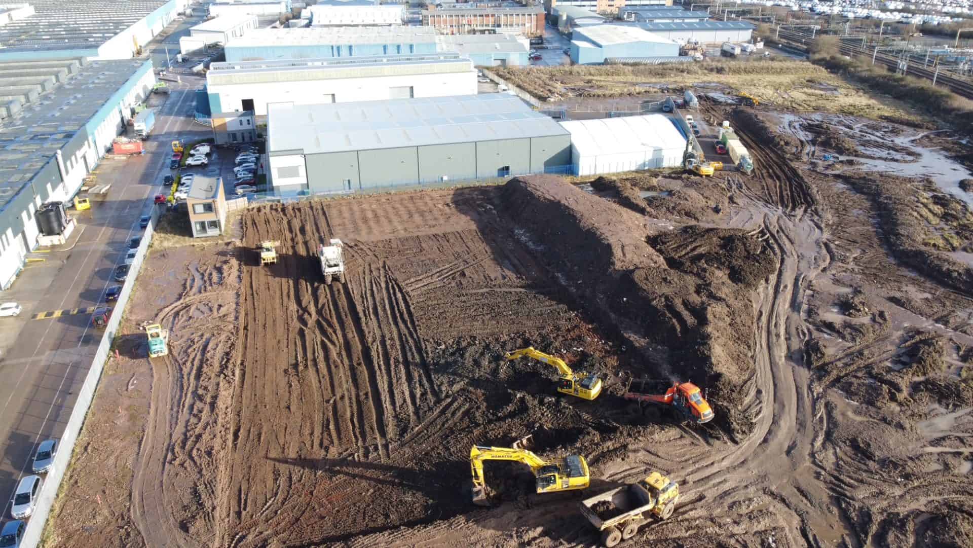 Construction site with excavators and dirt piles for building development.