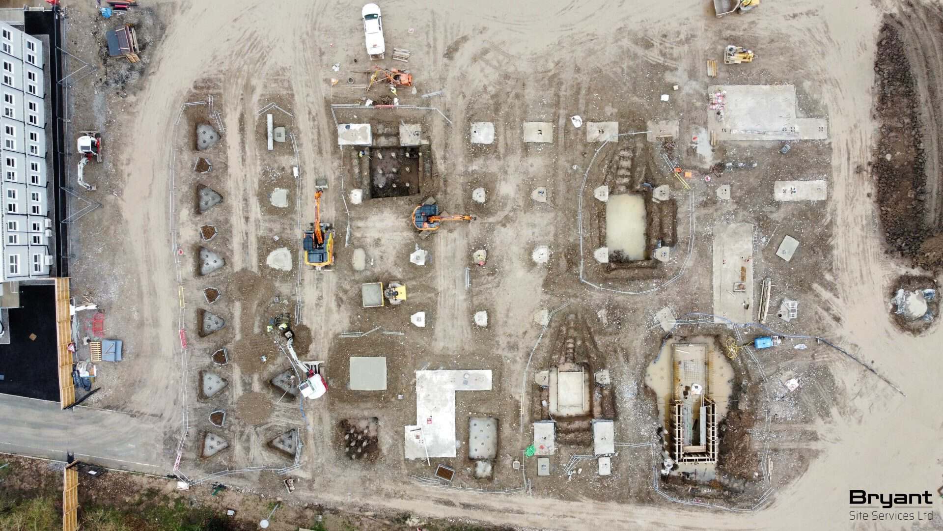Construction site with foundation work and machinery in progress.