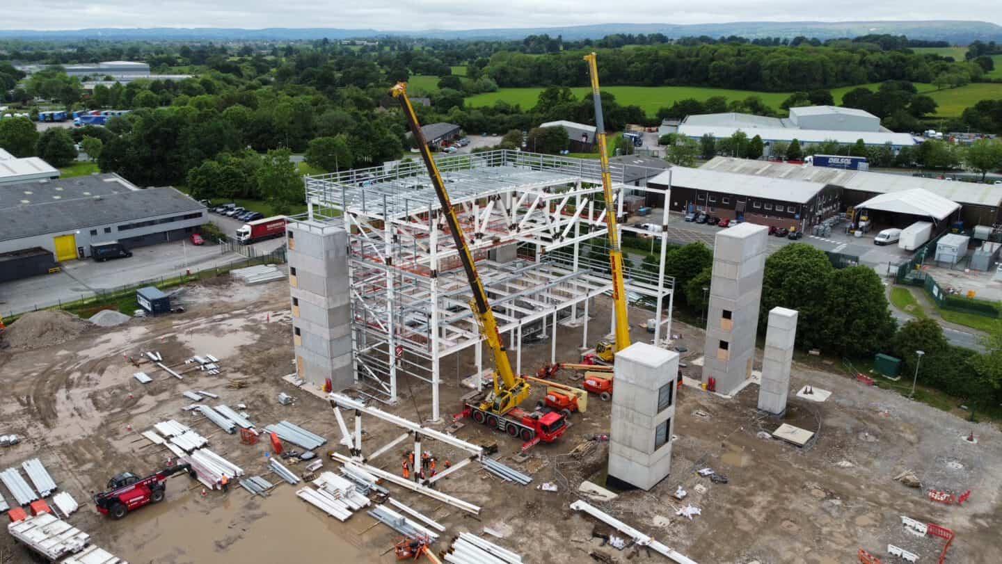 Construction site with steel framework and cranes in progress.