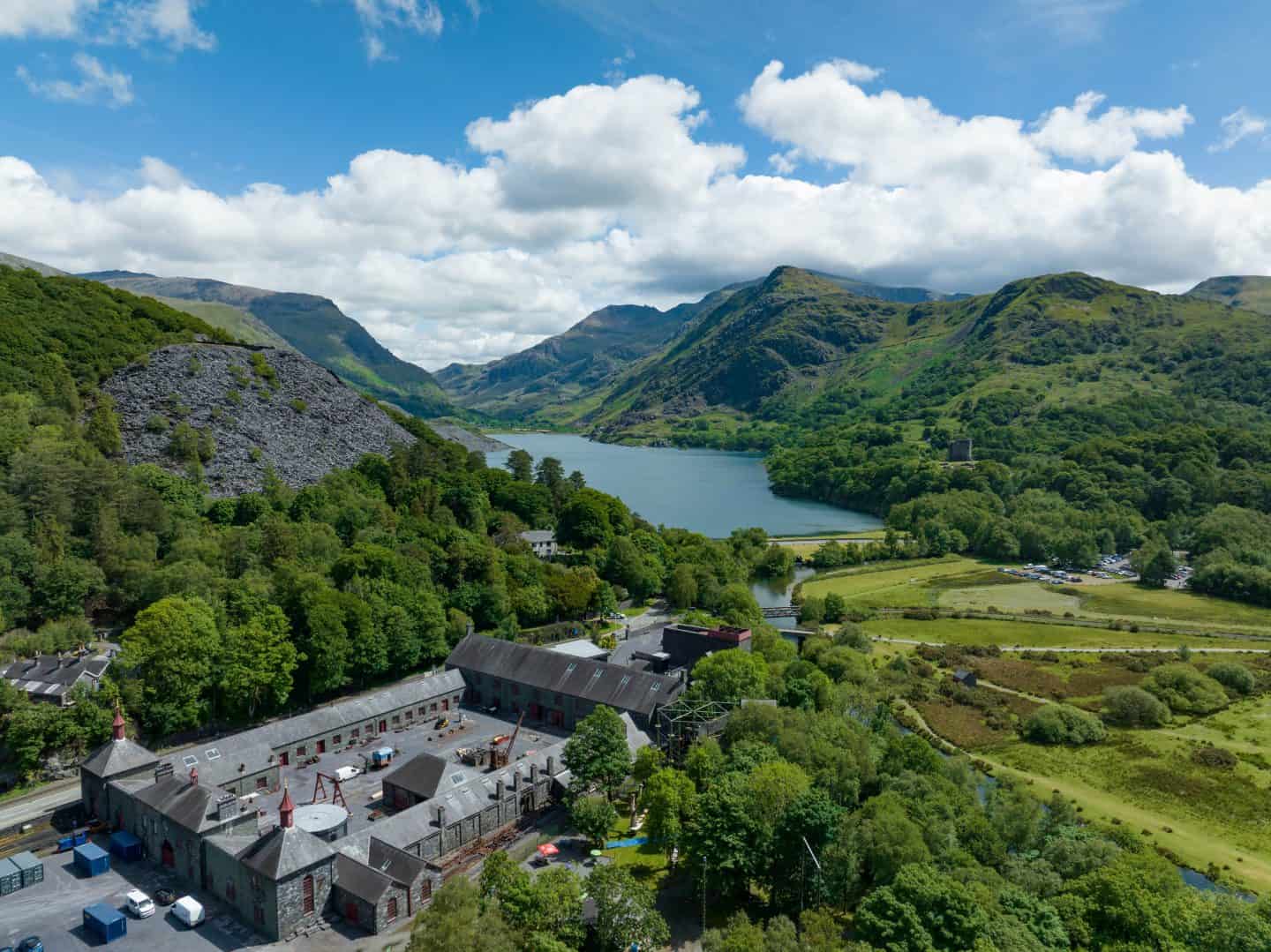 Beautiful lake surrounded by lush green mountains and forests in a scenic rural setting.