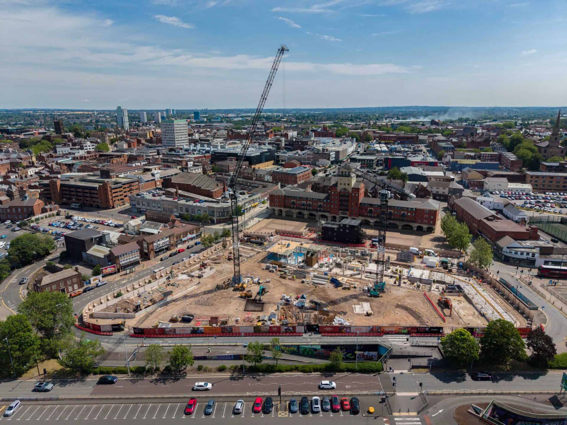 Aerial view of a construction site with crane in urban area.