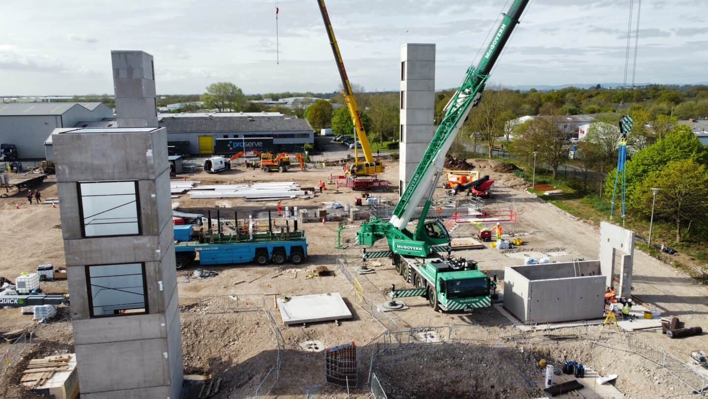 Construction site with cranes, building frames, and construction equipment in progress.