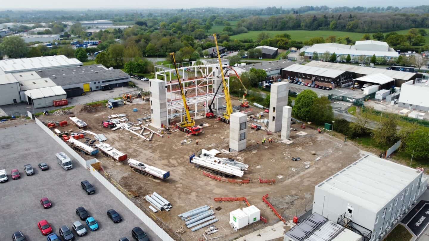 Construction site with cranes and building foundations in progress.