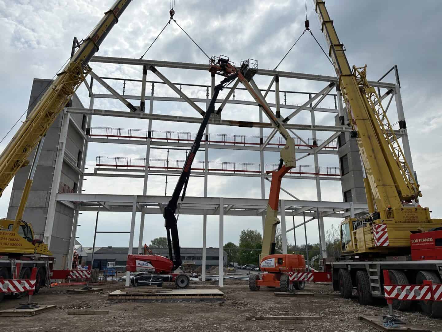 Construction site with cranes and steel framework for new building.