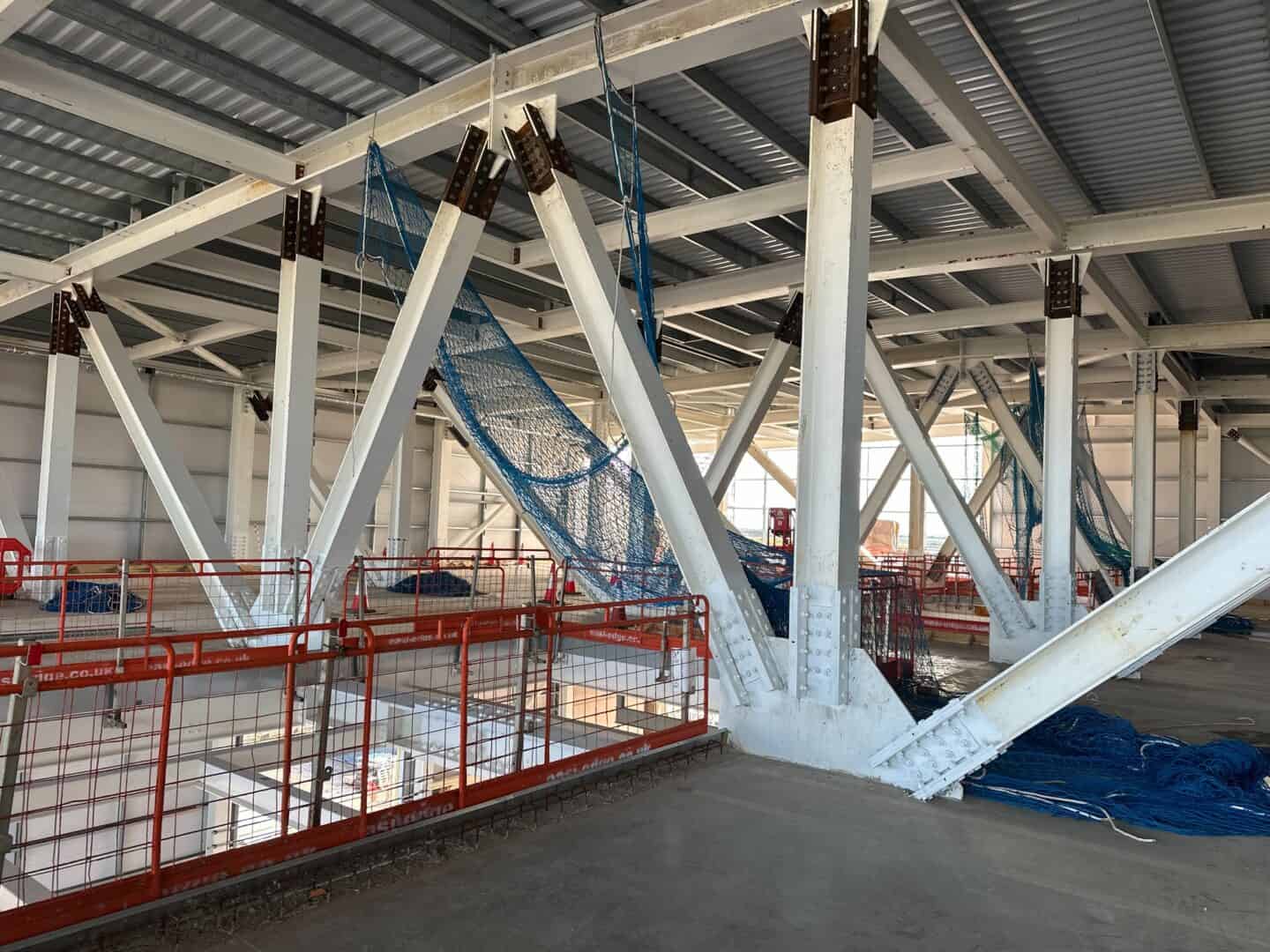 Steel framework and safety barriers at construction site.