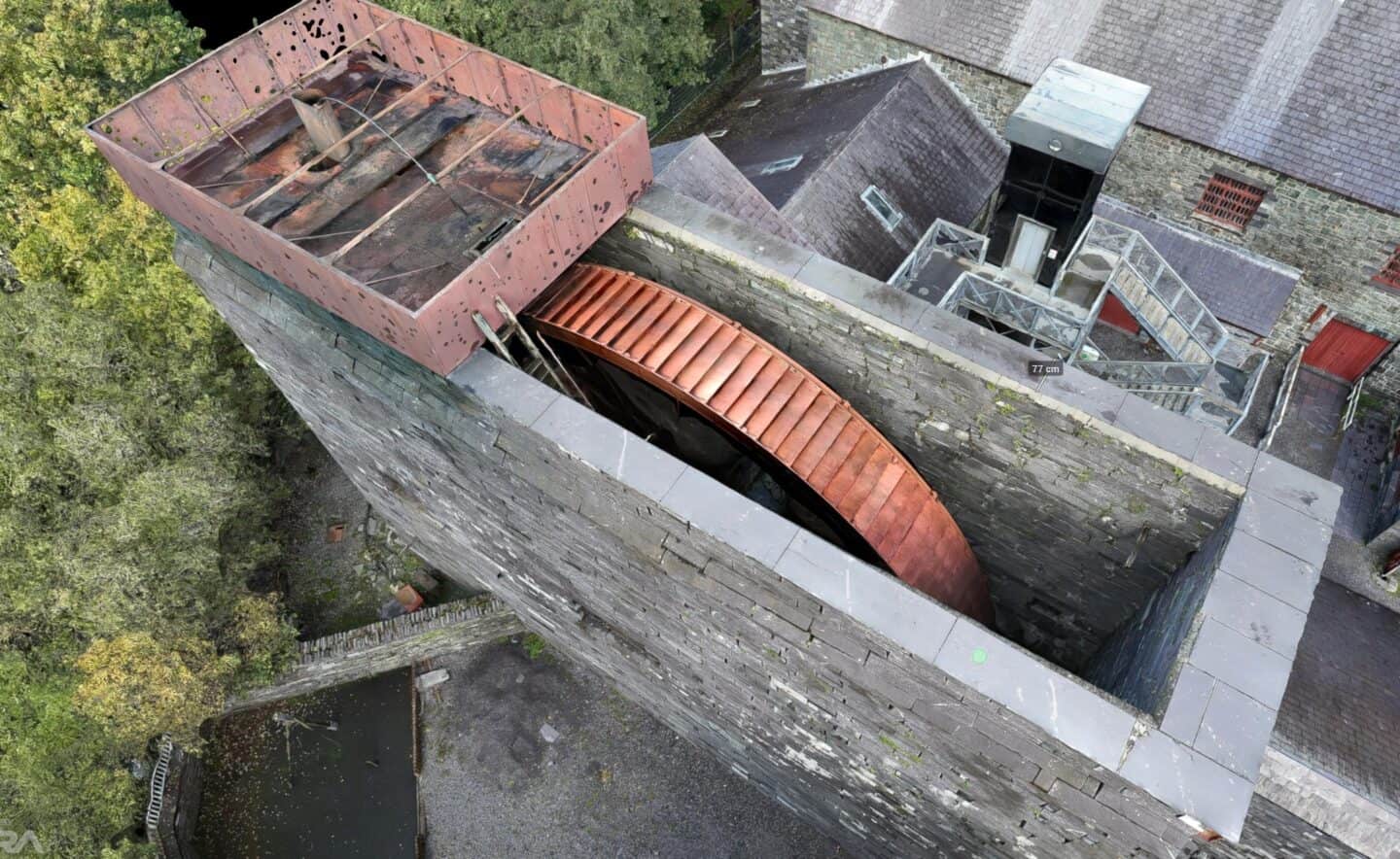 Aerial view of a stone tower undergoing renovation with new roofing work.